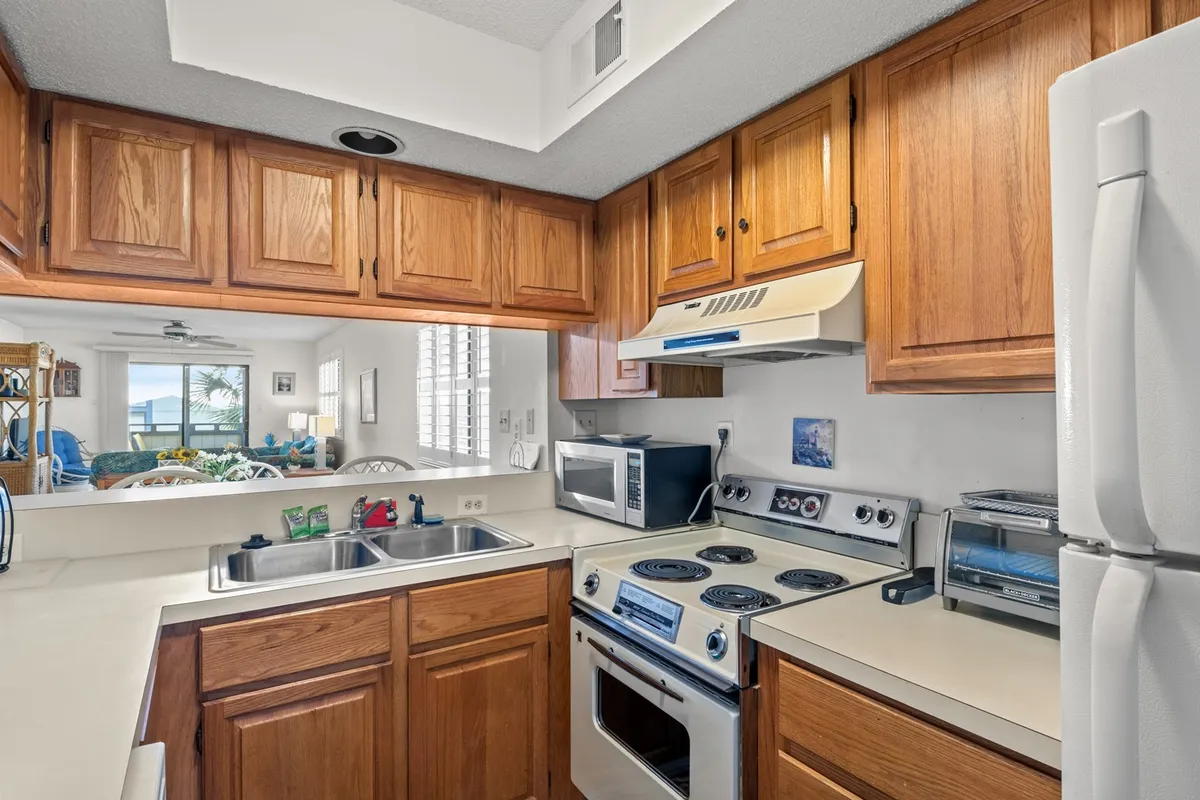 This image centers on the kitchen, showcasing modern appliances, wooden cabinetry, and generous counter space. The scene feels warm and inviting, emphasizing the kitchen as a hub for preparing meals and gathering with loved ones.