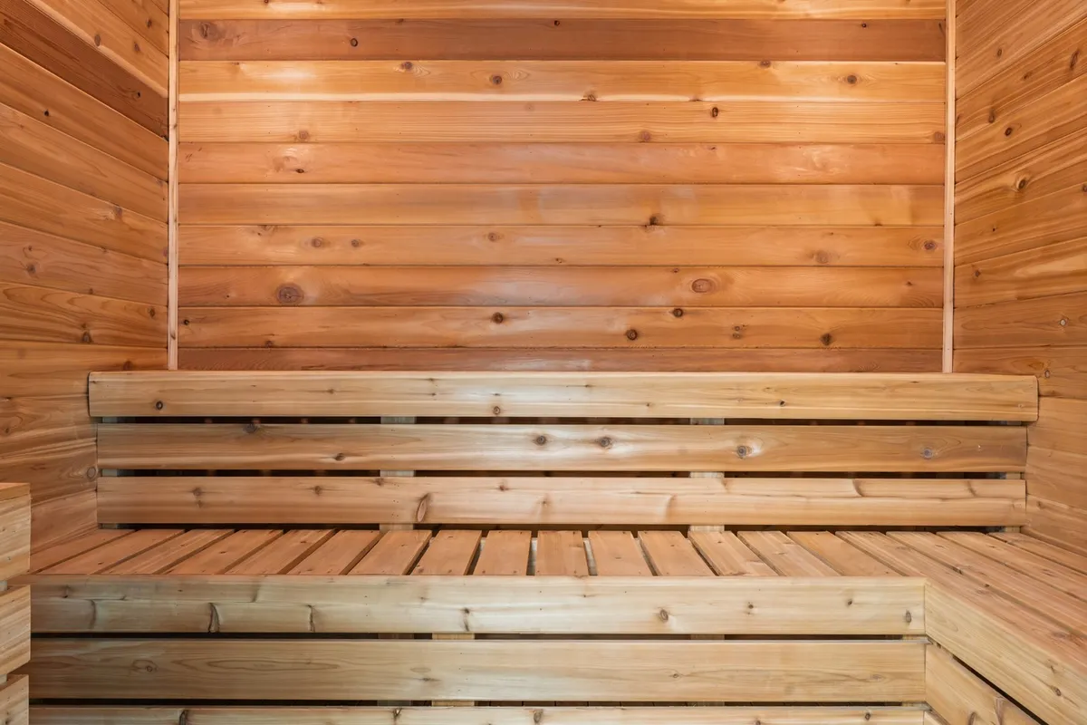 A tranquil sauna interior with warm wooden benches and walls, inviting guests to relax and unwind. The soft lighting and peaceful setting suggest a soothing escape, ideal for post-swim relaxation or quiet moments before heading out for the night.